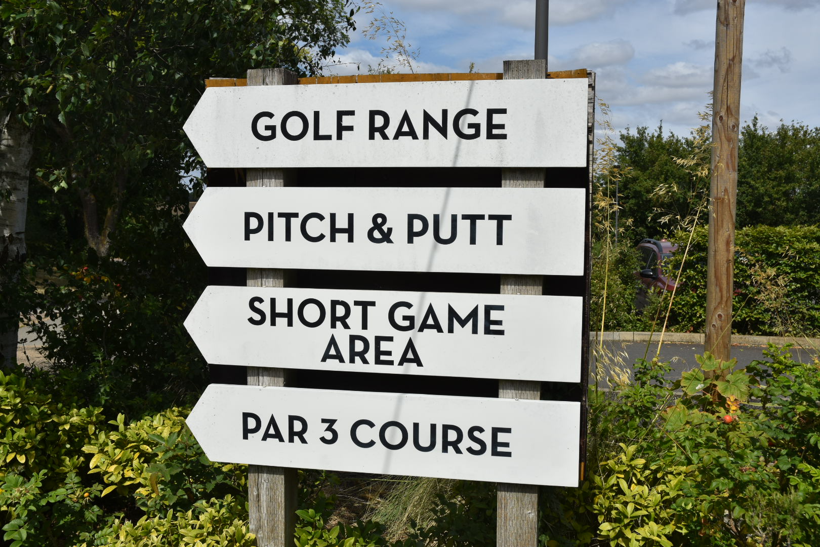 A signpost pointing to the golf range, pitch and putt, short game area and par 3 course