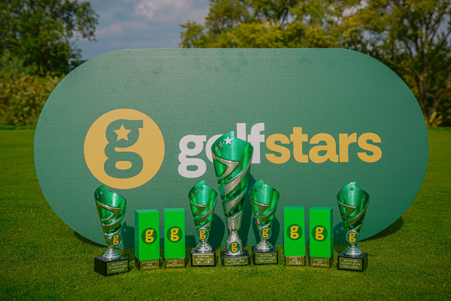 Golfstars Matchday trophies lined up in front of a Golfstars sign