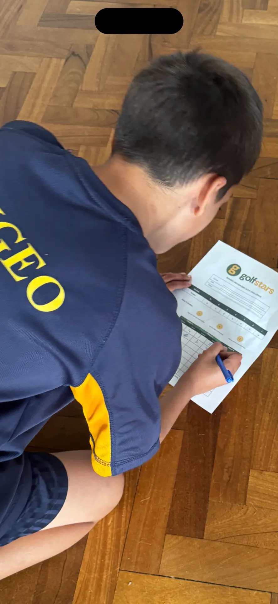 Pupil filling in a Golfstars scorecard during a school session