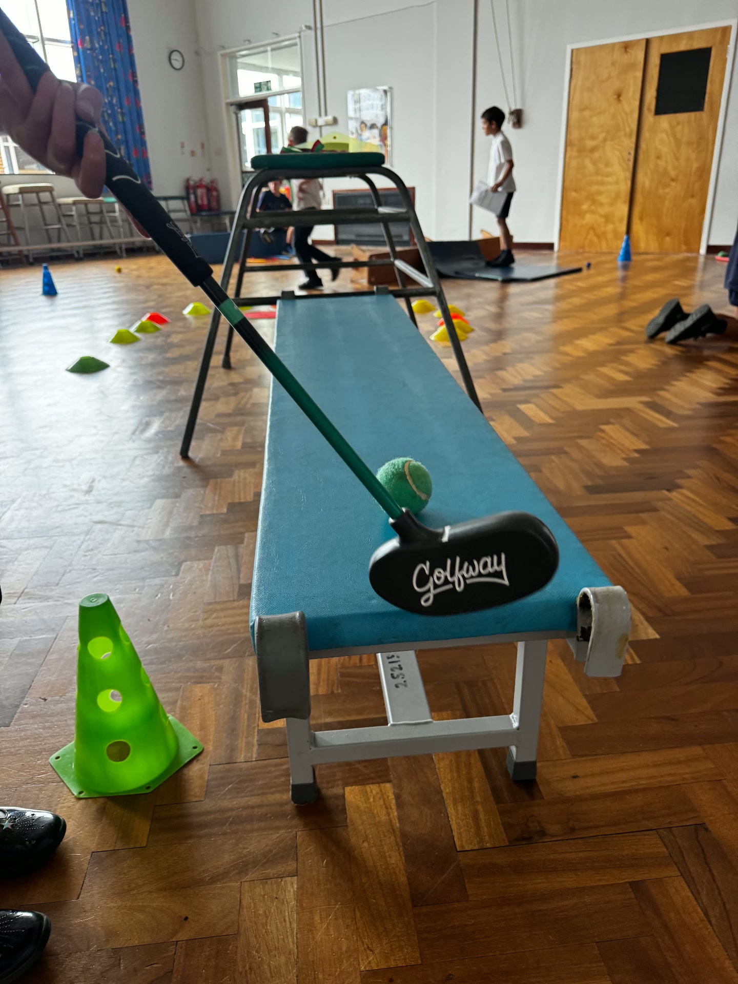 Indoor putting practice with a Golfstars putter in a school hall