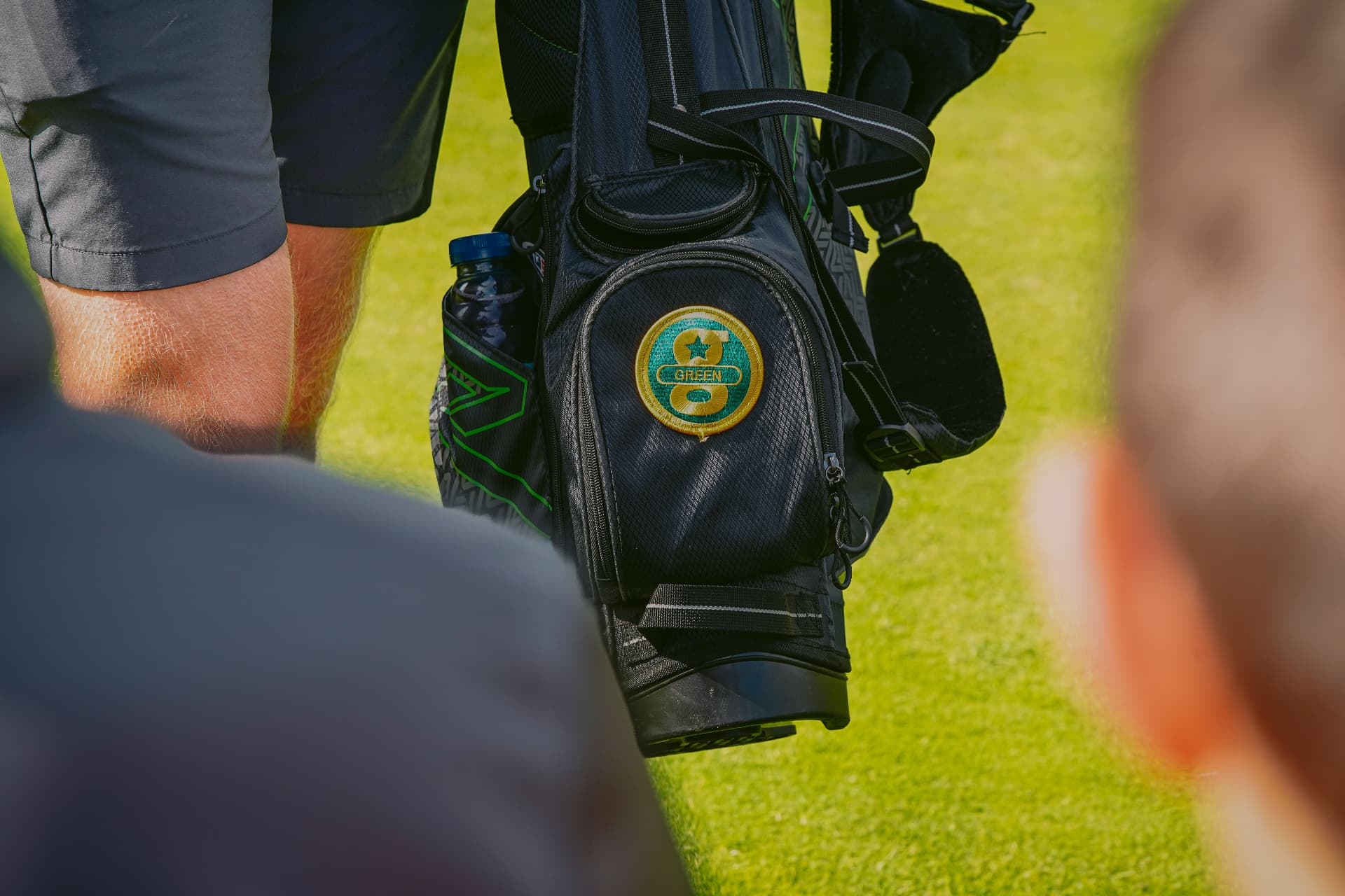 A child and their parent caddy walking down the fairway together