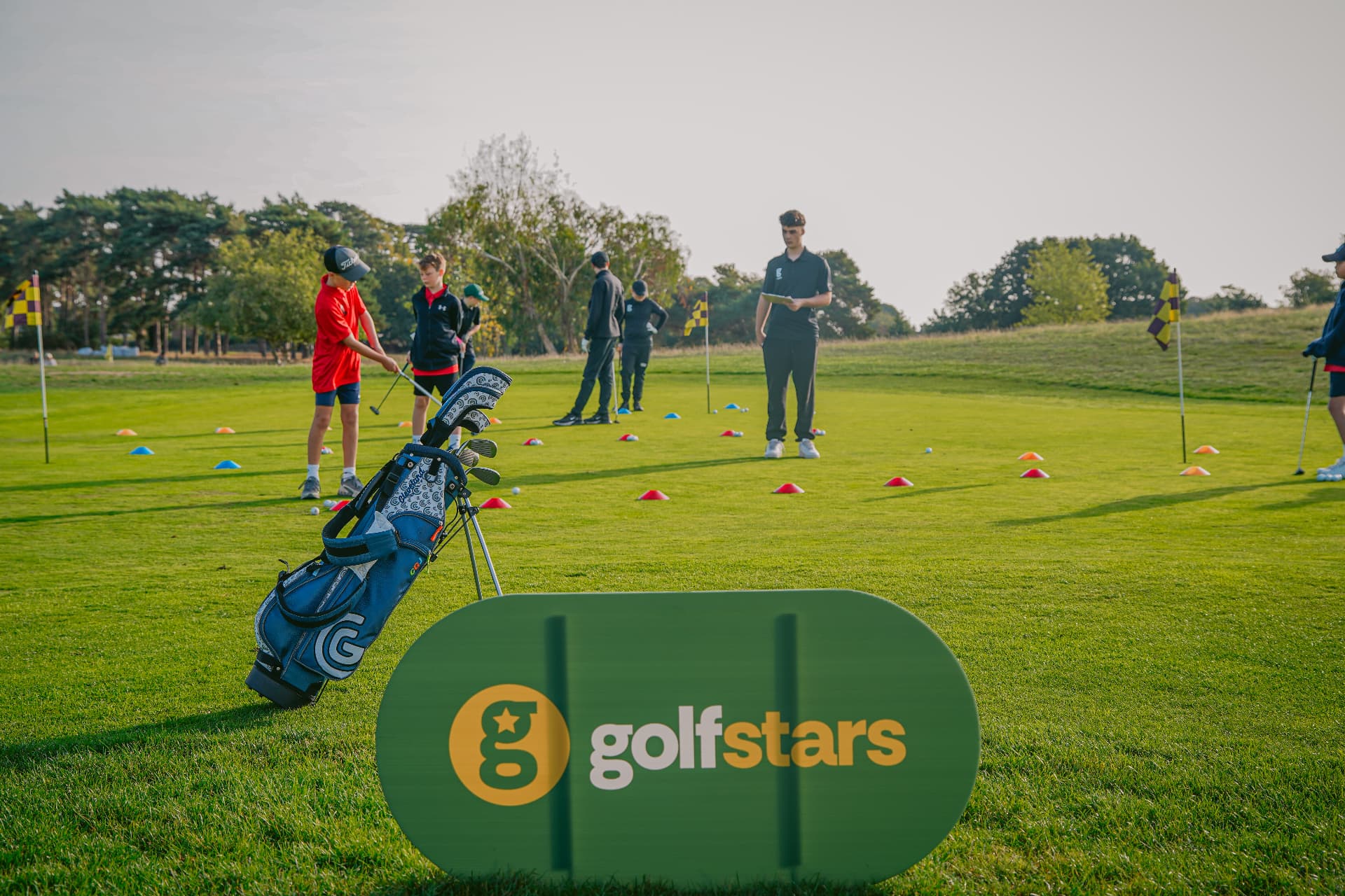 Golfstars group session on the practice green with a coach and juniors